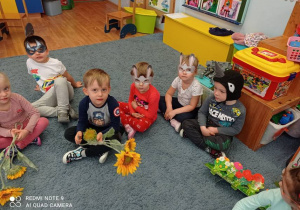 Dzieci z wykorzystaniem rekwizytów wcielają się w rolę kwiatków, zajączków, ptaszków, przygotowują się do przedstawienia bajki „Czerwony kapturek”.